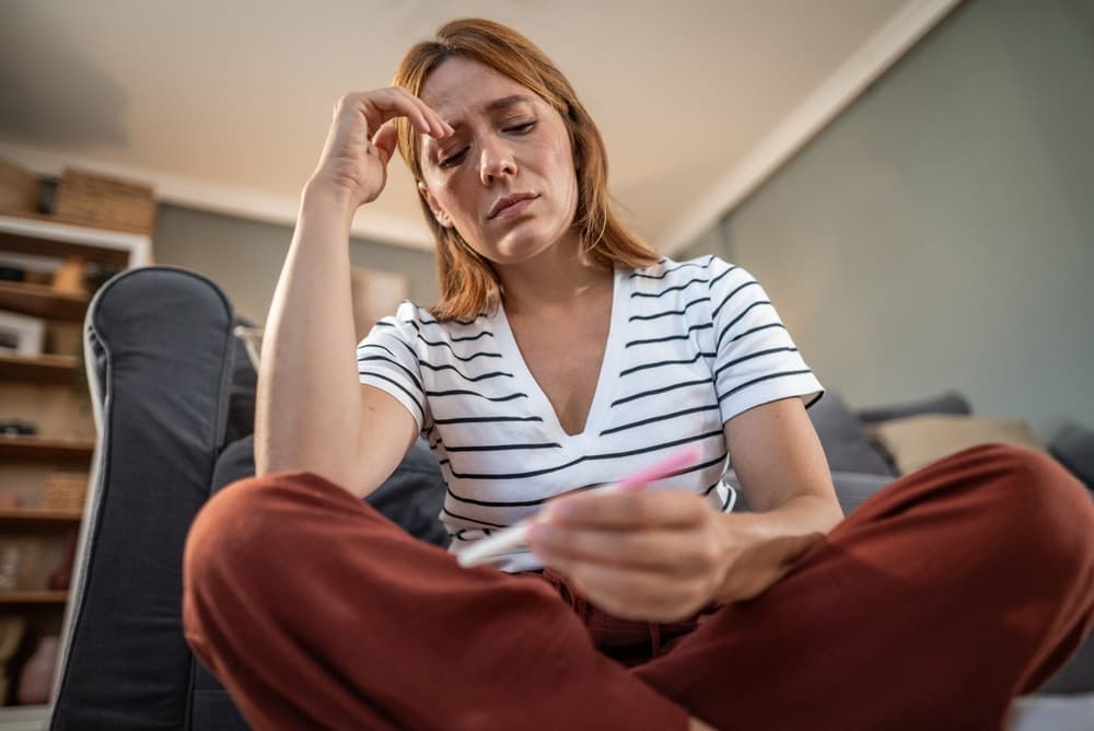 woman feeling devastated after another negative pregnancy test